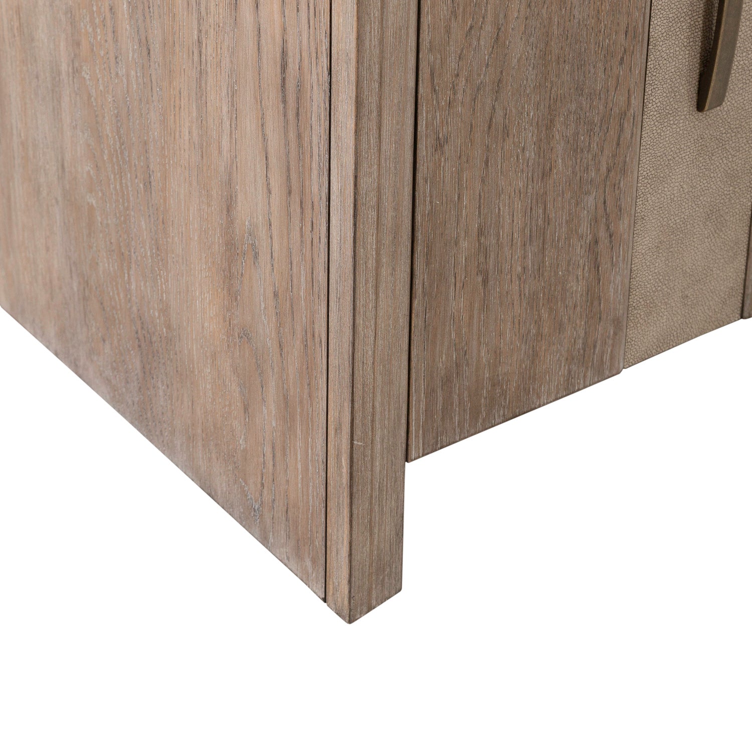 Close-up of the bottom corner of the Lafayette Curio Cabinet 2219-AC1000 by Liberty Furniture, showcasing the rich texture and grain of the wood, along with a partial view of a handle on the right—emphasizing meticulous craftsmanship and practical storage.