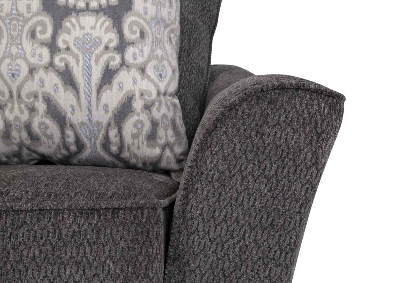 Close-up of the arm and cushion of the Fairmont Shasta Charcoal Sectional by Franklin Furniture Corp., upholstered in dark gray fabric and paired with a decorative pillow featuring a gray and white pattern—an ideal accent for any modern living space.