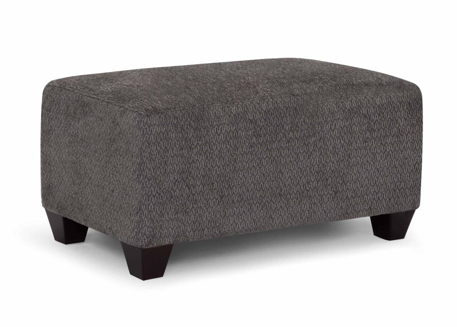Part of the Fairmont Collection by Franklin Furniture Corp., the Fairmont Shasta Charcoal Ottoman 25619-3043-05 is a stylish home furnishing, featuring a rectangular gray upholstered design with short black wooden legs, set against a plain white background.