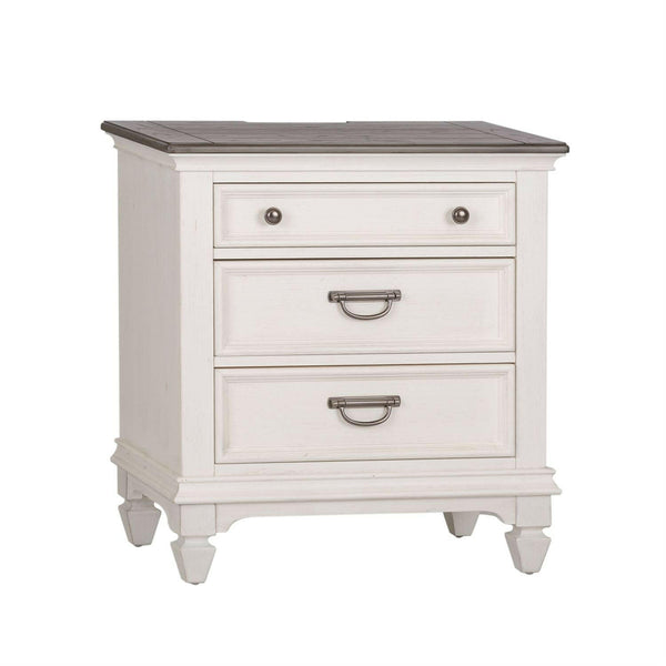 White wooden nightstand with three drawers; the top drawer has a small round knob, and the two lower drawers have metal handles. The nightstand stands on four short, tapered legs.