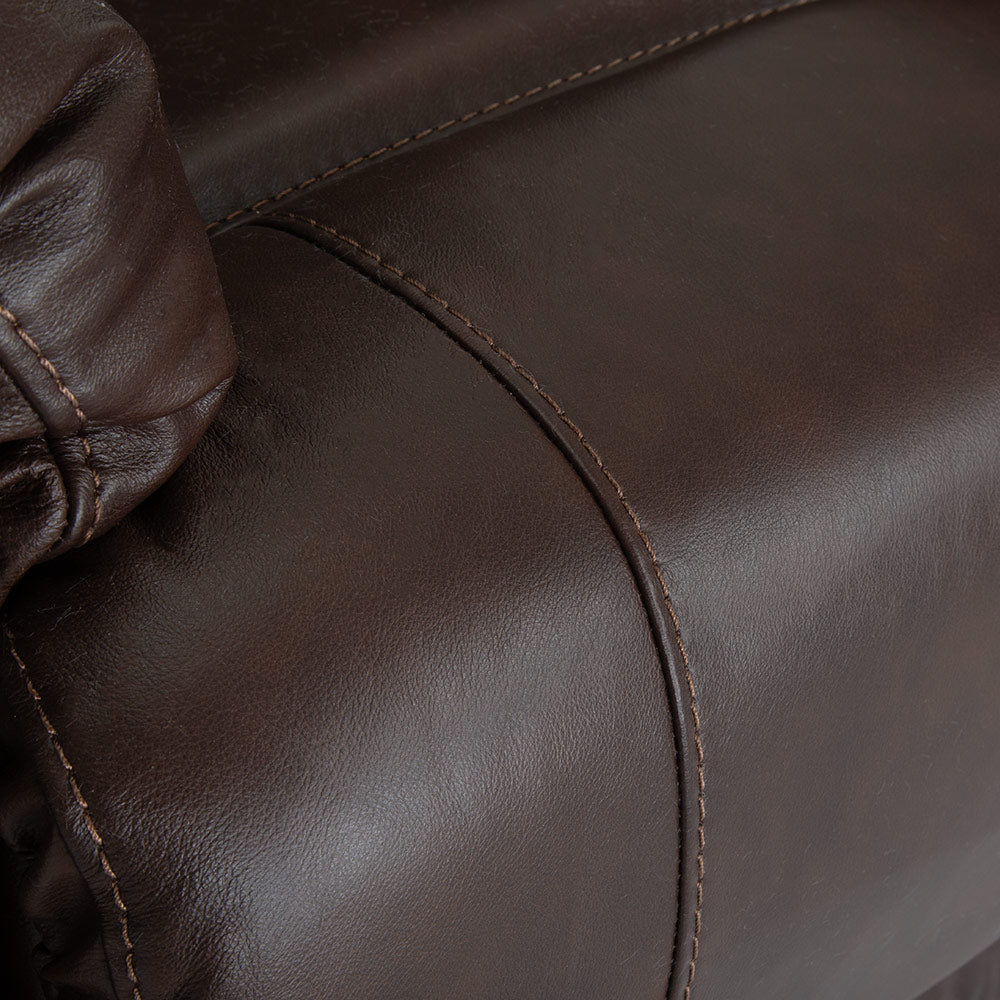 Close-up of the Trilogy Frederica Brown Recliner 4595-LM98-15 by Franklin Furniture Corp., highlighting the detailed stitching and textured finish on the armrest and cushion. This dark brown leather armchair features gel-blended cushions, ensuring exceptional comfort and lasting durability.