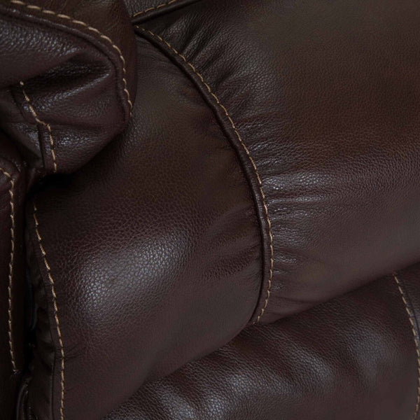 Close-up of dark brown leather upholstery with visible stitching and a padded, tufted texture—signature details of the Connery Blaze Bourbon Recliner 4703-LM99-14 by Franklin Furniture Corp. The supple surface is paired with a Gel-blended Foam Cushion for enhanced comfort, making this Leather Rocker an inviting addition to any space.