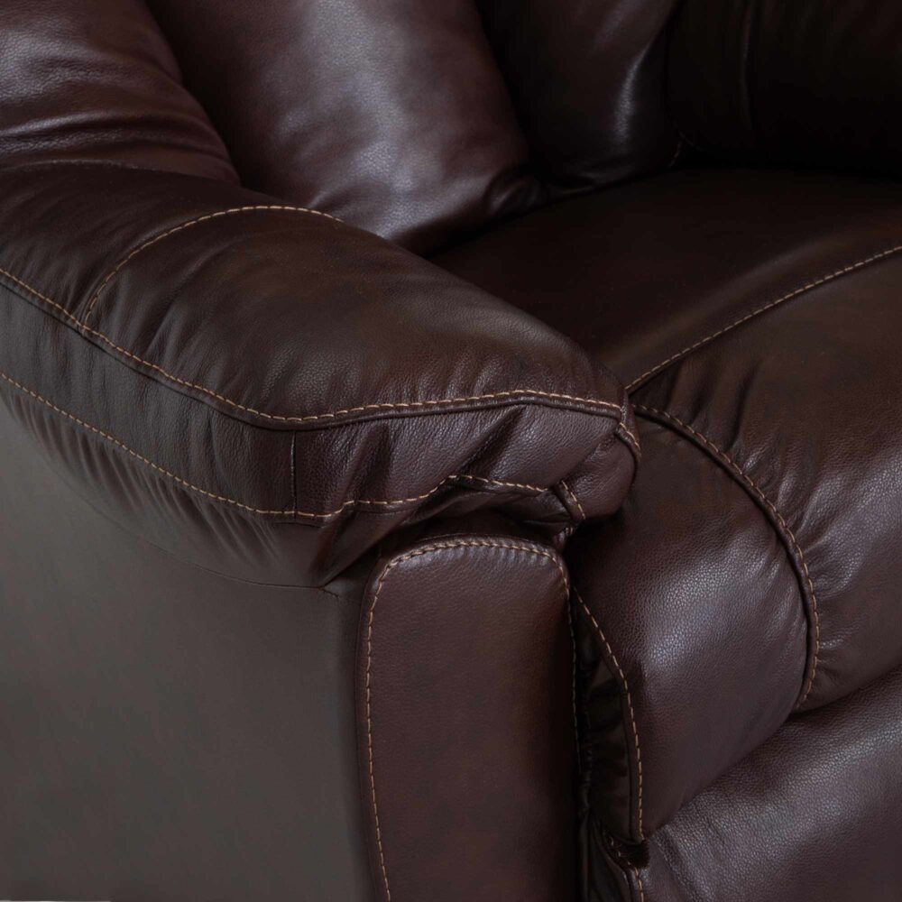 Close-up of the armrest and cushion of the Connery Blaze Bourbon Recliner by Franklin Furniture Corp. (model 4703-LM99-14) in dark brown leather, featuring visible stitching and a soft, gel-blended foam cushion for added comfort.