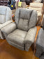 A large, gray upholstered Jasper Recliner 709-10-D1825-73 by La-Z-Boy is displayed in a furniture showroom alongside similar chairs. A yellow sale tag is visible on another chair in the background.