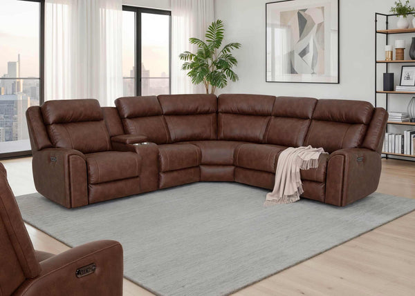 A spacious brown leather Phoenix Seattle Auburn Sectional 693-31-56-99-7511-18 by Franklin Furniture Corp. with power recline functionality is arranged in a bright living room. A beige throw blanket rests on one seat, and there’s a plant, artwork, and shelves in the background, with city views visible outside.