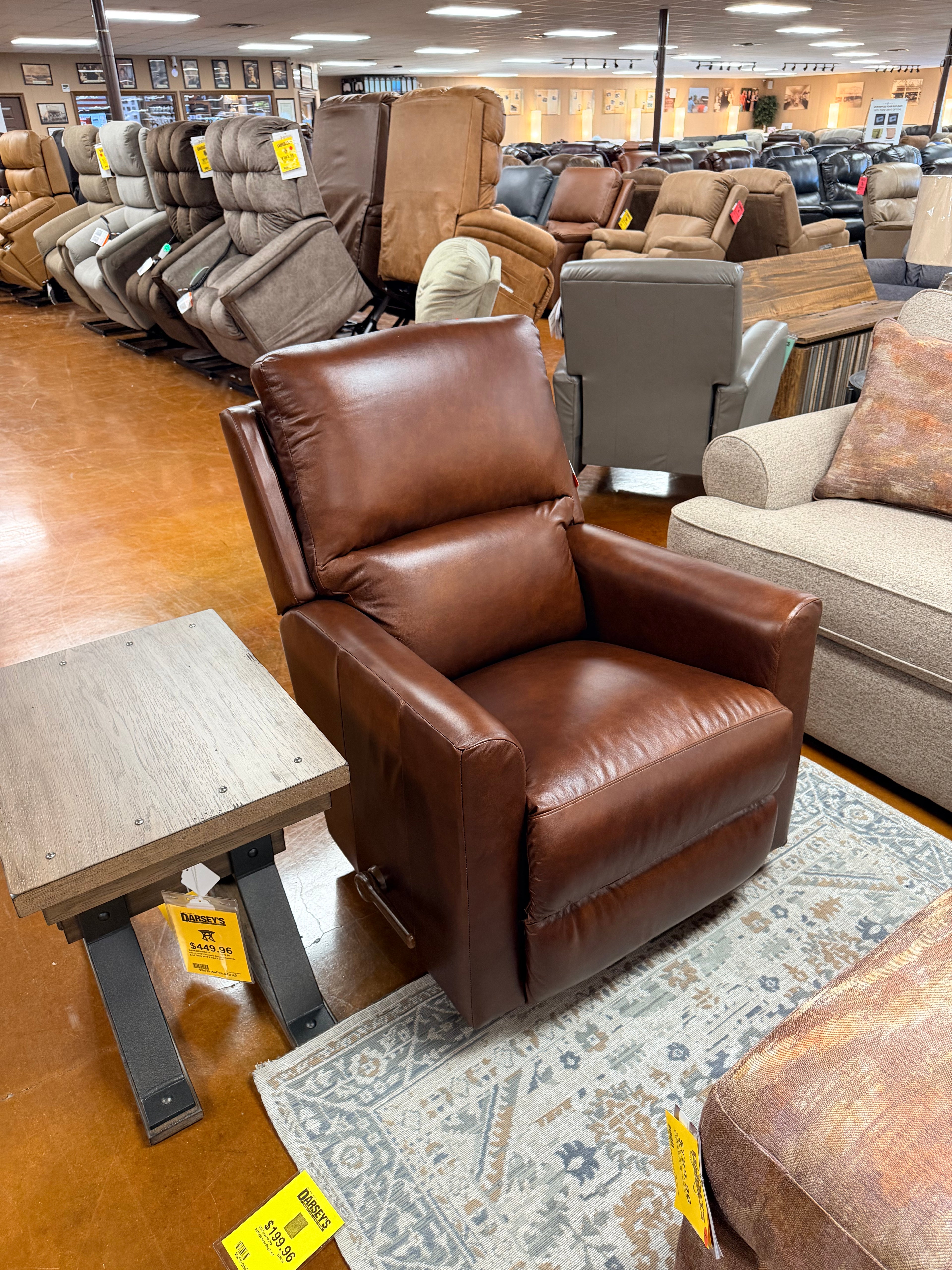 Brown leather recliner sofa in a furniture store with various items around