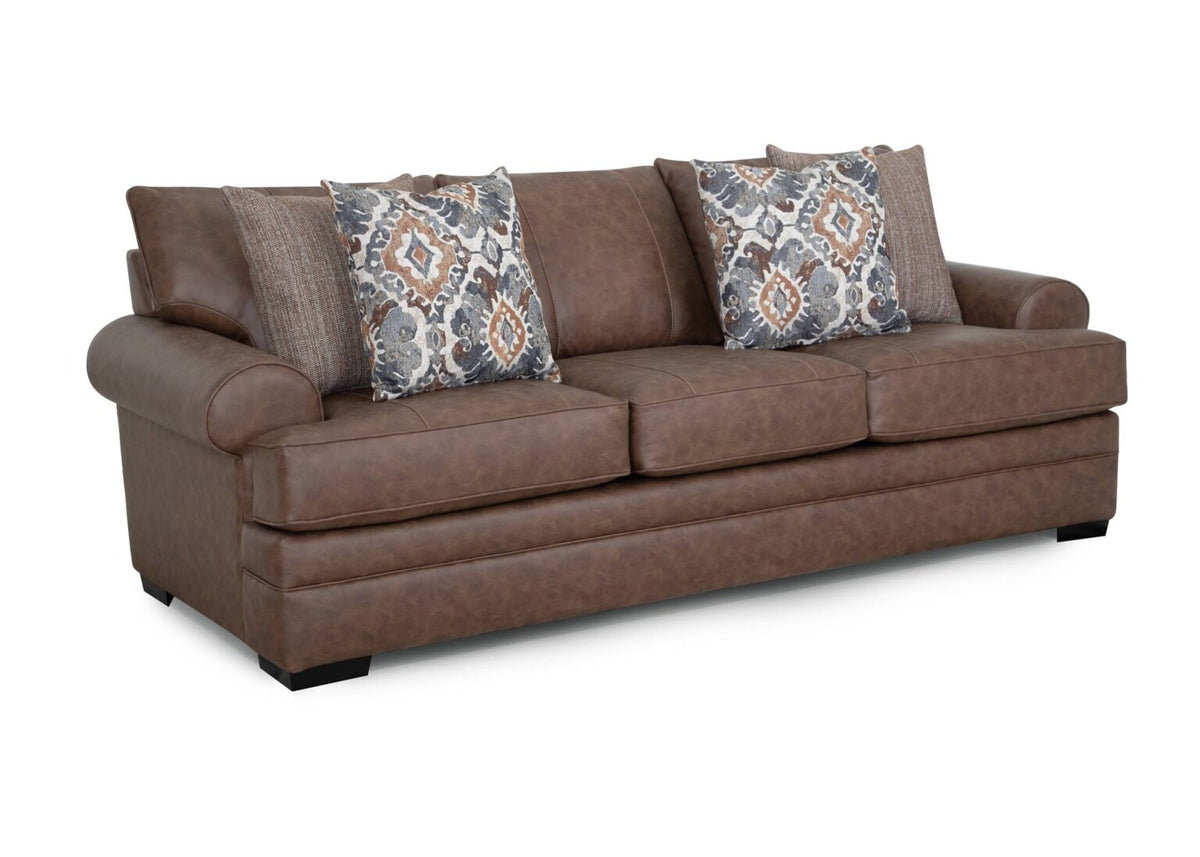 The Langston Duvall Vintage Brown Sofa (83240-3429-16) by Franklin Furniture Corp. features three seat cushions, rounded armrests, and comes with four decorative pillows in a mix of patterned and textured fabrics. Set against a white background, this vintage brown sofa showcases classic design elements and includes the signature WOW Seating System for enhanced comfort.