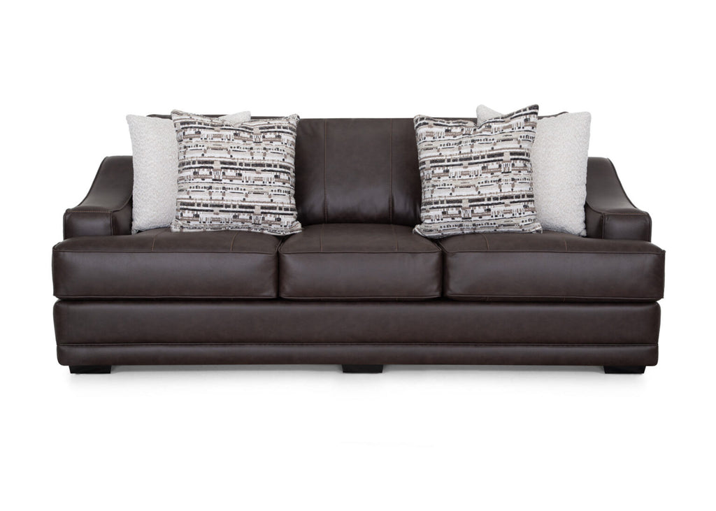A Prescott Duvall Coffee Sofa (model 89340-3429-10) by Franklin Furniture Corp., upholstered in dark brown with three seat cushions and four decorative throw pillows—two with geometric patterns and two in a light solid color—is displayed against a white background, highlighting the comfort of its WOW Seating System.