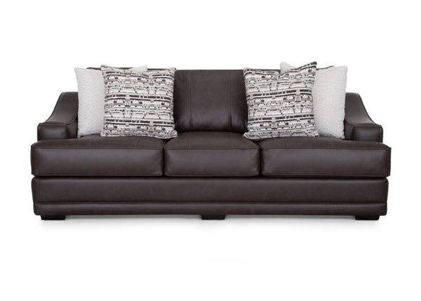 A Prescott Duvall Coffee Sofa (model 89340-3429-10) by Franklin Furniture Corp., upholstered in dark brown with three seat cushions and four decorative throw pillows—two with geometric patterns and two in a light solid color—is displayed against a white background, highlighting the comfort of its WOW Seating System.