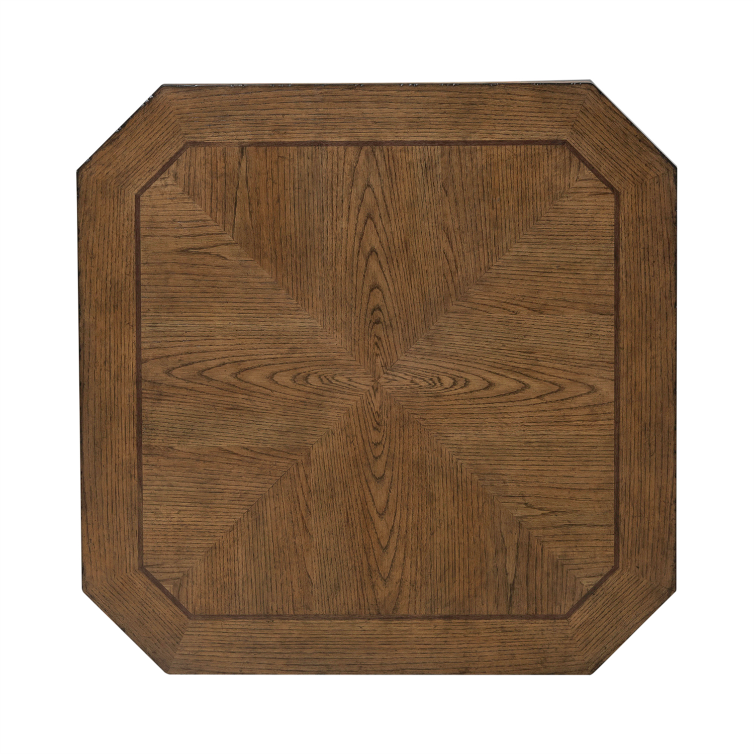 The Carolina Park Cocktail Table 930-OT1010 by Liberty Furniture features a square wooden tabletop with beveled, subtly angled corners and a symmetrical geometric wood grain pattern that radiates from the center. Its medium brown finish evokes the refined look of an elegant wood veneer coffee table.