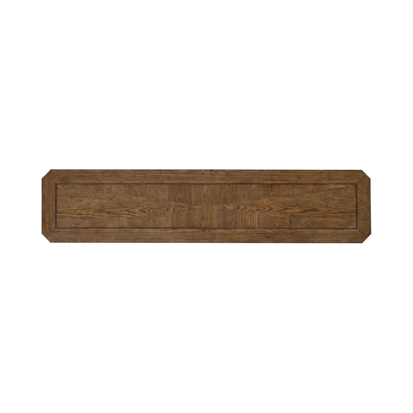 A long, rectangular wooden panel with beveled edges and a visible wood grain pattern, crafted from white oak veneers in an Amber Brown finish by Liberty Furniture. The corners are cut at an angle, giving the piece an octagonal appearance at each end—reminiscent of the refined style of the Carolina Park Sofa Table 930-OT1030.