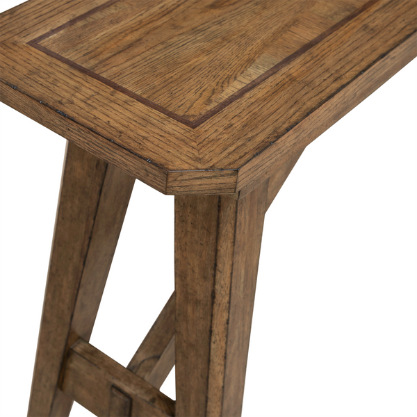 A close-up view of the Carolina Park Sofa Table 930-OT1030 by Liberty Furniture showcases its rectangular top with visible grain in an Amber Brown finish and angled legs crafted from white oak veneers.