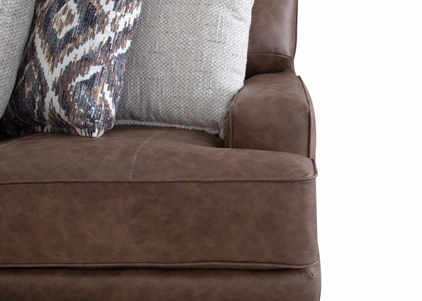 Close-up of the Asheville Duvall Vintage Brown Sectional 934-04-59-69-86-3429-16 by Franklin Furniture Corp., adorned with two decorative pillows—one showcasing a gray knit texture and the other featuring a patterned design—set against a white background. Experience ultimate comfort and style with this sectional, enhanced by the signature WOW Seating System.