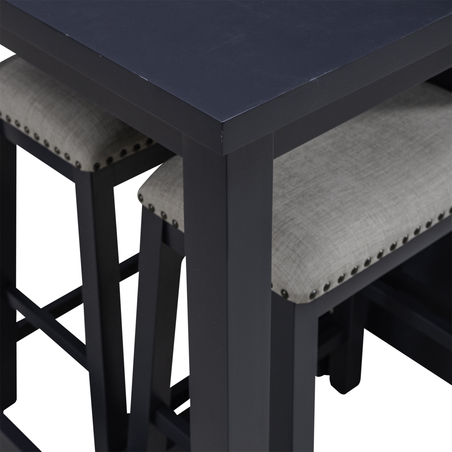 Close-up of the Liberty Furniture Brook Creek Table and 2 Chairs set (942NY-CD-3CTS), showcasing a sleek black wooden tabletop paired with two matching chairs featuring light gray cushioned seats and nailhead trim, partially tucked beneath the table—an ideal setup for small space dining.