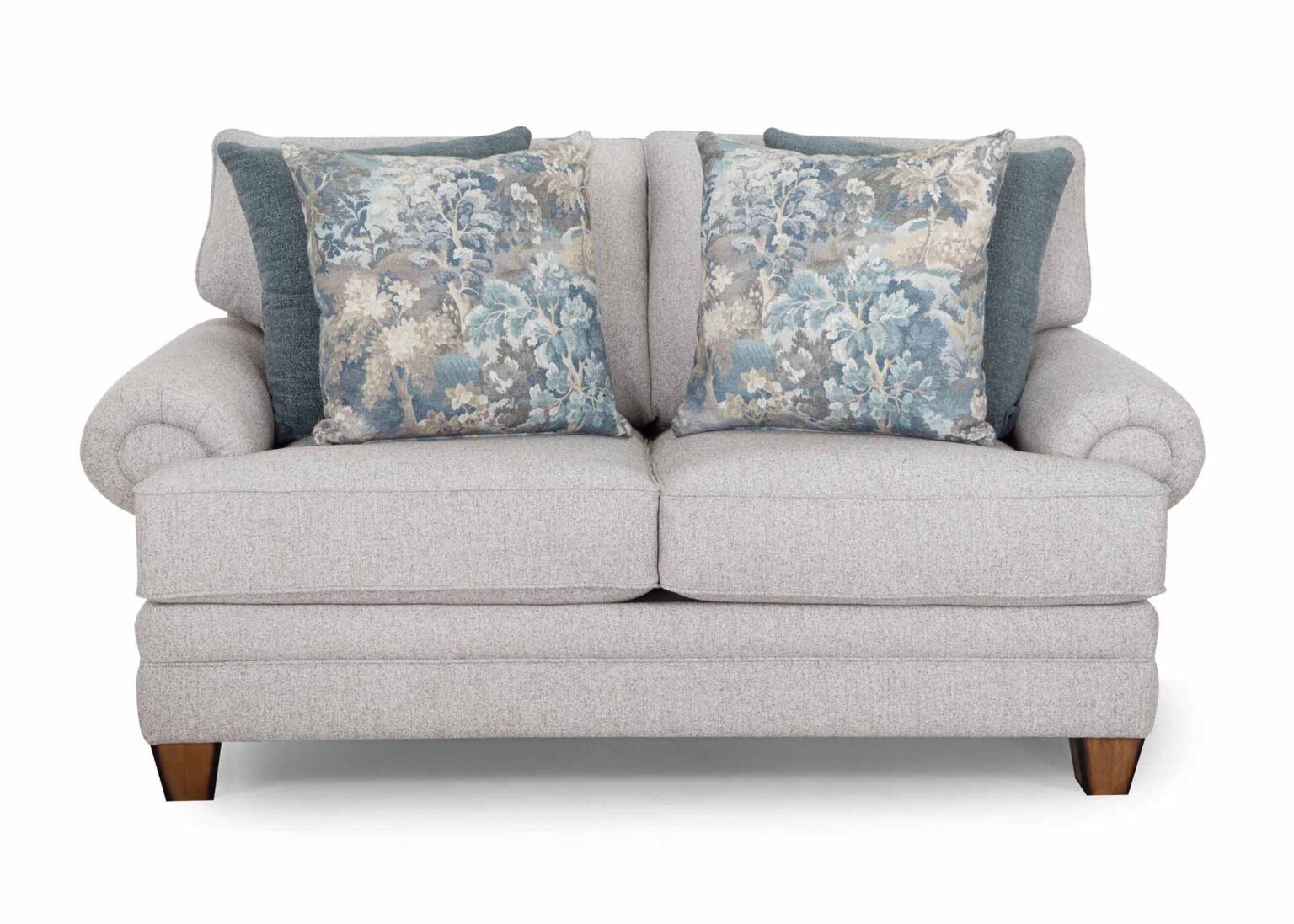 A light gray upholstered Annisa Julien Cork Loveseat (model 95720-3574-20) by Franklin Furniture Corp., featuring two large decorative pillows with blue and beige floral patterns in front of two solid blue pillows. The loveseat includes reversible seat and back cushions, rolled arms, wooden legs, and is designed for superior comfort with the WOW Seating System.