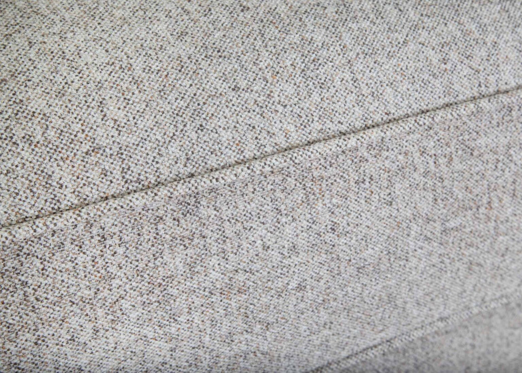 Close-up of light gray textured fabric upholstery with a visible seam running horizontally through the middle of the image, highlighting the exceptional craftsmanship of the Annisa Julien Cork Sofa 95740-3574-20 by Franklin Furniture Corp., featuring its WOW Seating System and reversible seat cushions.