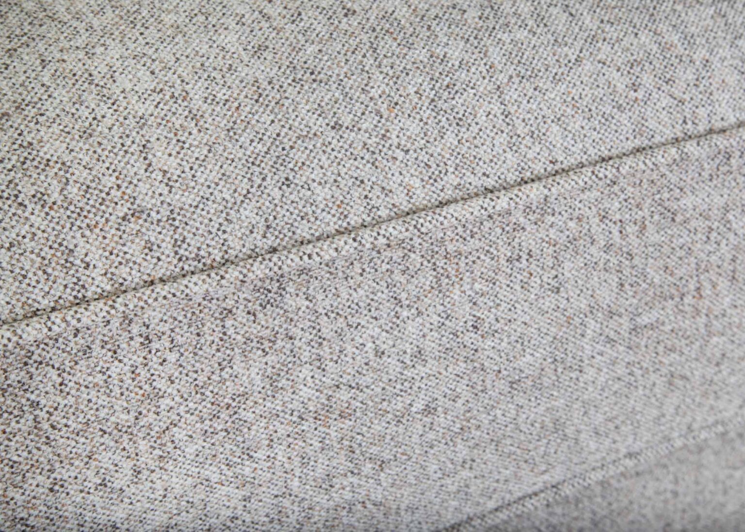 Close-up of light gray textured fabric upholstery with a visible seam running horizontally through the middle of the image, highlighting the exceptional craftsmanship of the Annisa Julien Cork Sofa 95740-3574-20 by Franklin Furniture Corp., featuring its WOW Seating System and reversible seat cushions.