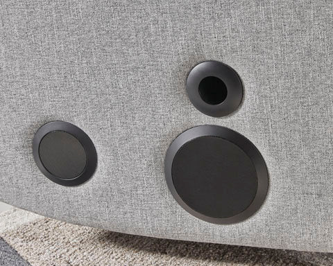 The Pineland Pewter Power Recliner 9930642A in gray textured fabric features three circular black speaker inserts.