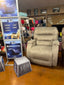 A gray Mastodon Mushroom Recliner 9B34-18449 from Best Home Furnishings is shown in a store beside signs that read "Beast," "Longevity," and a block marked "500 lbs." Behind this heavy-duty recliner, colorful blankets are neatly folded on the shelves.