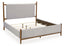 The Ashley Lyncott Gray Queen Bed (model B615-81/97) features a cushioned headboard and light gray upholstered sides, supported by a sturdy wooden frame with exposed legs. This contemporary queen upholstered panel bed showcases visible slats and a mattress-free frame, creating a modern and sleek aesthetic.