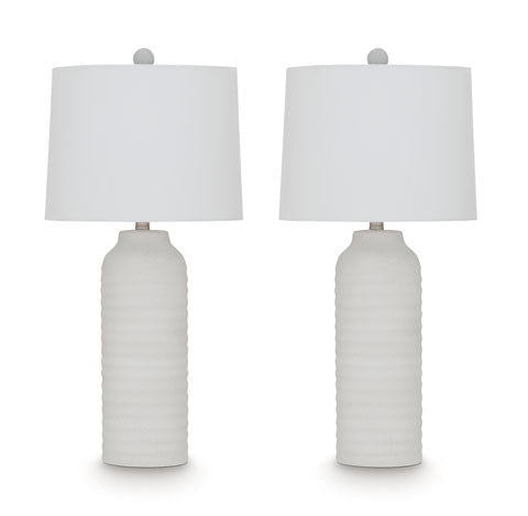 Two identical Vauville White Lamps (L243674) by Ashley, featuring textured cylindrical bases and round white lampshades, are placed side by side on a plain white background.