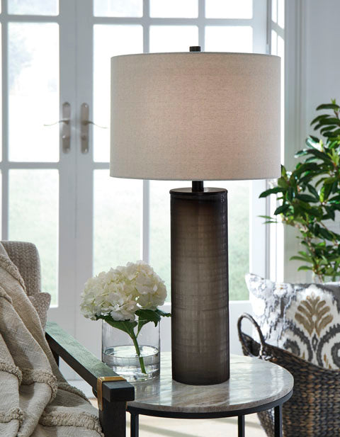 Dingerly Lamp L430824 with a frosted glass ombre base and a drum shade, sitting on a round stone side table next to a vase of white hydrangeas.