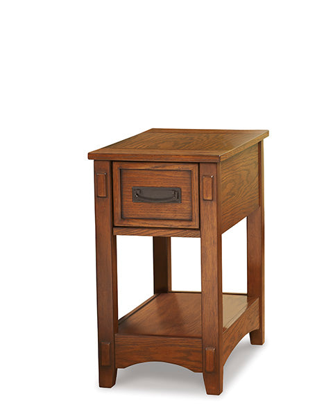 The Breegin Brown Chairside End Table T007-319 is a narrow, rectangular Mission-style wooden end table featuring one drawer with a dark metal pull and a lower shelf.