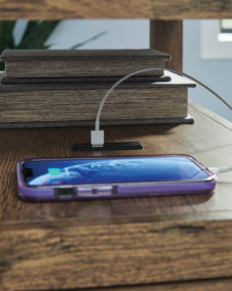 A smartphone in a purple case charging via built-in USB ports on a Fendenmore Brown Chairside End Table T190-117 next to two stacked books.