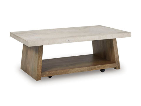 The Ashley Brendalhouse Cocktail Table T642-1 features a modern rectangular design with a thick, light-colored faux cement tabletop, angled wooden legs, a lower wooden shelf, and small caster wheels underneath for easy mobility.