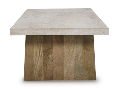 The Ashley Brendalhouse Cocktail Table (T642-1) showcases a contemporary design with its light-hued faux cement tabletop and broad wooden rectangular base, presented against a plain white background.