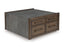The Ashley Kallenny Cocktail Table (T669-8) features a square design with a concrete-like top and sides, complemented by four wooden drawers with metal handles on one side. With its blend of raw materials and clean lines, this table brings a strikingly modern, industrial edge to your space.