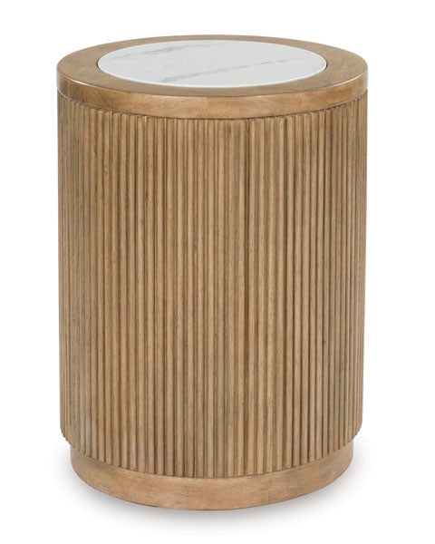 The Ashley Camdill End Table T808-6 features a cylindrical wooden base with vertical grooves and a round faux Carrara marble top, making it an elegant addition to any contemporary living room.