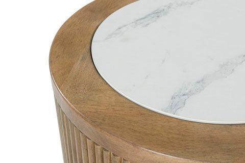 The image features the Ashley Camdill End Table T808-6, showcasing its elegant round wooden design with a fluted side and a white faux Carrara marble top insert accented by light gray veining—a sophisticated addition to any contemporary living room.