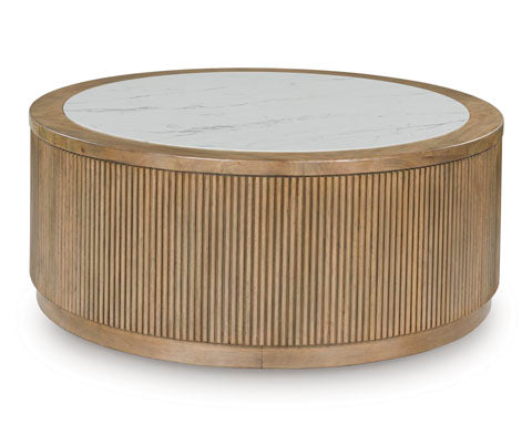 The Camdill Coffee Table T808-8 by Ashley features a round silhouette with a ribbed wooden base and a smooth white marble top. This contemporary centerpiece blends natural wood tones with sleek stone, offering a modern and minimalist design for your living room.