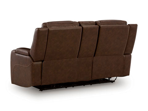 A rear view of the Ashley Knightington Brown Power Reclining Loveseat U1160218A, featuring plush cushioning, brown leather upholstery, and visible reclining mechanisms.
