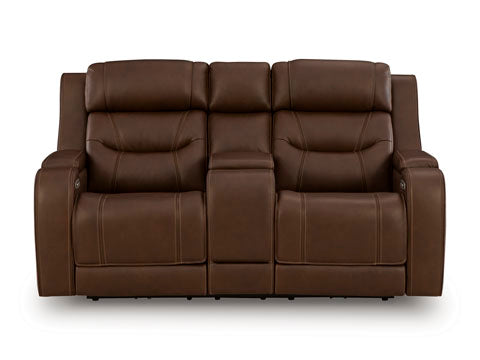 The Ashley Knightington Brown Power Reclining Loveseat (U1160218A) is a two-seater brown leather home theater sofa, featuring a central armrest and built-in cup holders. Viewed from the front against a white background, this piece combines comfort and style, making it the perfect addition to your entertainment space.