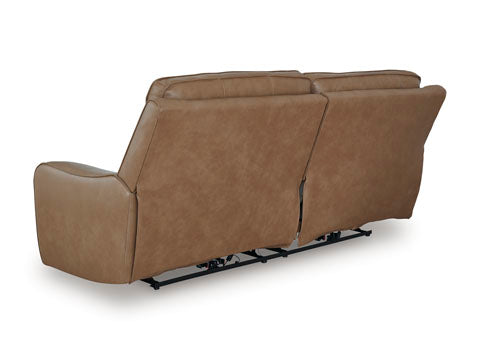 The Ashley DeepWakes Caramel Power Reclining Sofa (U6260647) is displayed from the back, highlighting its plush cushions and visible recliner mechanisms beneath the top-grain leather upholstery.
