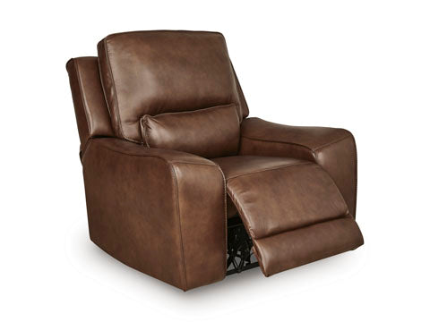 The Ashley DeepWakes Canyon Power Recliner U6260713 is upholstered in luxurious top grain brown leather and features padded armrests, a cushioned back, and an extended footrest. Shown angled to highlight its contemporary design and power reclining functionality.