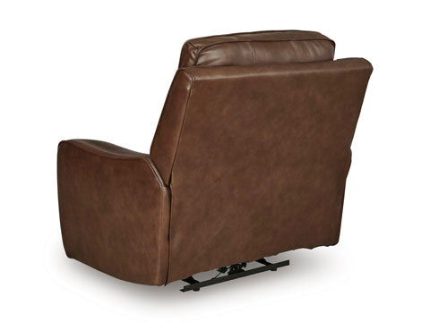 The Ashley DeepWakes Canyon Power Recliner U6260713 is shown from the back in brown top grain leather, featuring visible seams and a slightly angled backrest. This recliner includes an adjustable headrest for added comfort, padded armrests, and rests on a black metal base.