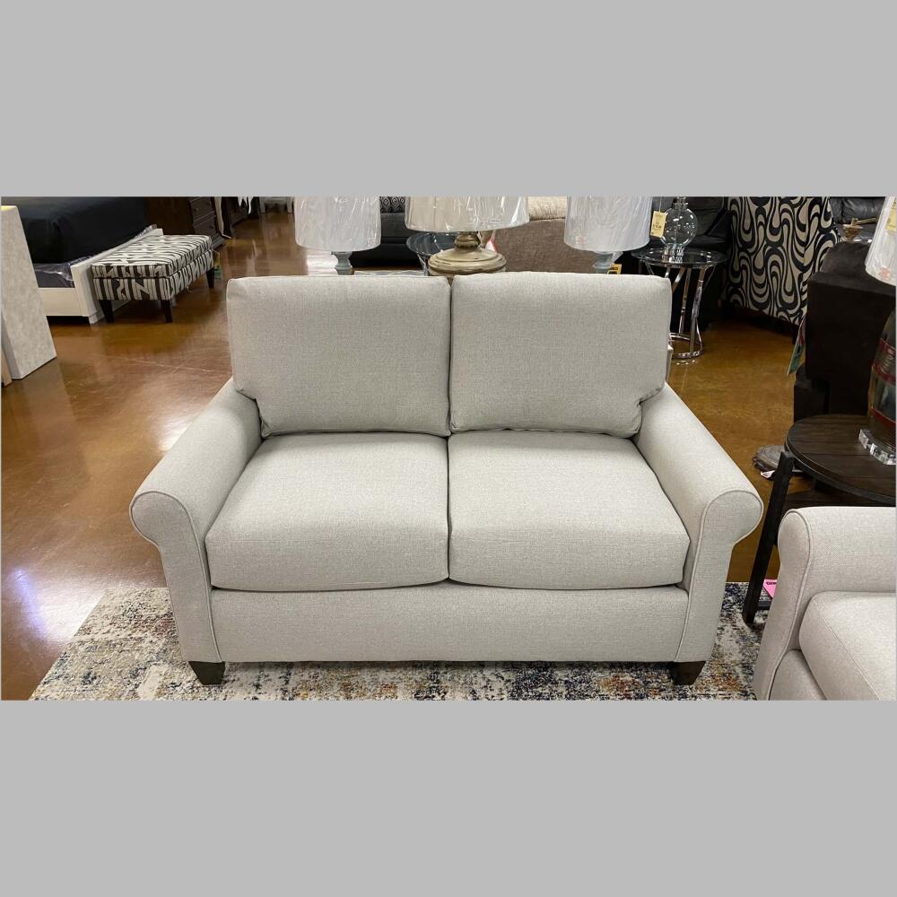 Small scale rolled arms and tapered wood legs in a brindle finish define the loveseat, while a welted finish on the arms accentuates the graceful curve.